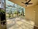 Enclosed patio with tile floor and ceiling fan, overlooking a lush, green landscape, offering a relaxing outdoor space at 13526 Norman Cir, Hudson, FL 34669