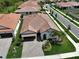 Aerial view of a single-Gathering home with a red tile roof, paver driveway, and lush landscaping at 17152 Scuba Crest St, Wimauma, FL 33598