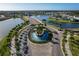 Stunning aerial view of a community roundabout with a beautiful water feature, surrounded by lush landscaping and scenic lakes at 17152 Scuba Crest St, Wimauma, FL 33598
