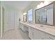 Bathroom features double vanity with white countertops, decorative mirrors, tile floors, and green walls at 17152 Scuba Crest St, Wimauma, FL 33598