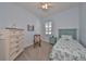 This bedroom features light blue walls, a ceiling fan, and a cozy bed with floral bedding at 17152 Scuba Crest St, Wimauma, FL 33598