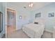 Comfortable bedroom with a ceiling fan, light walls, and view into bathroom provides a tranquil space for rest and relaxation at 17152 Scuba Crest St, Wimauma, FL 33598