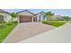 Front exterior of home with two car garage, tile roof and brick paver driveway at 17152 Scuba Crest St, Wimauma, FL 33598