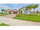 Beautiful single-story home showcasing a well-manicured lawn, palm trees and a two-car garage at 17152 Scuba Crest St, Wimauma, FL 33598