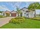 Charming home featuring a manicured lawn, palm trees, and a welcoming front entrance at 17152 Scuba Crest St, Wimauma, FL 33598