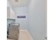 Well-lit laundry room with gray washer and dryer plus white cabinets for optimal storage at 17152 Scuba Crest St, Wimauma, FL 33598