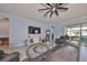 Spacious living room with ceiling fan, tile floors, and sliding glass doors to the outside patio at 17152 Scuba Crest St, Wimauma, FL 33598