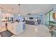 Open-concept living space with kitchen island and stainless steel appliances and large format tile at 17152 Scuba Crest St, Wimauma, FL 33598