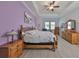 Bright bedroom with trey ceiling, hardwood floors, ceiling fan, with matching dressers and end tables at 17152 Scuba Crest St, Wimauma, FL 33598