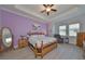 Bright bedroom with trey ceiling, hardwood floors, ceiling fan, and well-lit window at 17152 Scuba Crest St, Wimauma, FL 33598