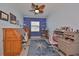 Comfortable office features light walls, built-in shelves, and wooden desks accented by a vibrant rug and ceiling fan at 17152 Scuba Crest St, Wimauma, FL 33598