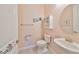 Charming powder room features a sleek pedestal sink, framed prints, and decorative cabinet for stylish functionality at 17152 Scuba Crest St, Wimauma, FL 33598