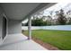 Covered patio and backyard featuring a white fence and green grass at 17406 Isaac Ln, Punta Gorda, FL 33955