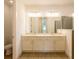 Bright bathroom featuring a double sink vanity, framed mirrors, and tiled flooring and shower stall at 17406 Isaac Ln, Punta Gorda, FL 33955