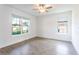 Bright, airy bedroom featuring two large windows, tile floors, and a ceiling fan at 17406 Isaac Ln, Punta Gorda, FL 33955