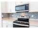 Close-up of the kitchen features stainless steel appliances and mosaic backsplash at 17406 Isaac Ln, Punta Gorda, FL 33955