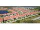 Aerial view of a residential area featuring homes with red tile roofs and a lush green environment at 17418 Holly Well Ave, Wimauma, FL 33598
