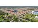 Wide aerial view showcasing a community with ponds and neat rows of homes with red roofs at 17418 Holly Well Ave, Wimauma, FL 33598