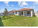 Wide-open backyard with lush grass, covered patio, and a privacy fence at 17418 Holly Well Ave, Wimauma, FL 33598
