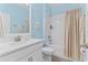 Bright bathroom with blue walls, white vanity, and shower-tub combination with tile surround at 17418 Holly Well Ave, Wimauma, FL 33598