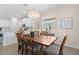Bright dining room boasts wood-look tile, dining table, and elegant light fixture near the kitchen at 17418 Holly Well Ave, Wimauma, FL 33598