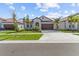 Charming single-Gathering home with a paver driveway, tropical landscaping, and a two-car garage at 17418 Holly Well Ave, Wimauma, FL 33598