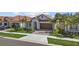 Inviting single-story home with a well-manicured lawn and a charming, tiled roof at 17418 Holly Well Ave, Wimauma, FL 33598