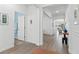 Hallway features wood-look tile flooring, white walls and trim, with views of the bathroom and living room at 17418 Holly Well Ave, Wimauma, FL 33598