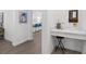 Hallway features wood-look tile flooring and white walls, leading to the kitchen and a small workstation at 17418 Holly Well Ave, Wimauma, FL 33598