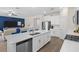Modern kitchen with white cabinets, stainless appliances, a large island with seating, and an open layout to the living area at 17418 Holly Well Ave, Wimauma, FL 33598