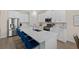 Bright kitchen featuring white cabinets, stainless steel appliances, and a quartz countertop island with bar seating at 17418 Holly Well Ave, Wimauma, FL 33598