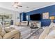 Bright living room features a coastal decor, plush seating, and sliding glass doors to the outdoor space at 17418 Holly Well Ave, Wimauma, FL 33598