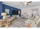 Spacious living room is beautifully decorated with neutral tones and decor, features a large television and comfortable seating at 17418 Holly Well Ave, Wimauma, FL 33598