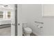 Toilet room features safety grab bars for convenience, and a peek at the main bedroom at 17418 Holly Well Ave, Wimauma, FL 33598