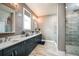 Well-lit bathroom featuring double sinks and vanities, tiled wall and a walk-in shower at 17716 Roost Pl, Lakewood Ranch, FL 34211