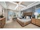 Serene main bedroom with coffered ceiling and lake views, complete with bench seating at 17716 Roost Pl, Lakewood Ranch, FL 34211