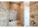 Walk-in shower featuring tan tile walls and showerhead with a corner bench for convenience at 17716 Roost Pl, Lakewood Ranch, FL 34211