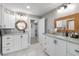 This bathroom features double sink vanities with decorative framed mirrors and a connecting room at 2085 Lynnwood Ct, Dunedin, FL 34698