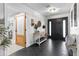 Bright foyer with black tile flooring, wooden door, table, and decorative accents at 2085 Lynnwood Ct, Dunedin, FL 34698