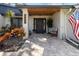 Inviting front entryway with stone tile, wooden door, wooden accents, and decorative plants at 2085 Lynnwood Ct, Dunedin, FL 34698