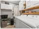 Bright laundry room featuring a washer, dryer, upper cabinets, and decor at 2085 Lynnwood Ct, Dunedin, FL 34698