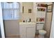 Well-lit bathroom featuring a single vanity, toilet, and storage cabinet, with tile flooring at 2222 Harper St, Tampa, FL 33605