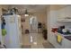 Bright kitchen featuring white appliances, cabinets, tiled floor and an open view to the bathroom at 2222 Harper St, Tampa, FL 33605