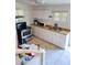 Kitchen features tiled floor, white cabinets and countertops, and stainless steel appliances at 2222 Harper St, Tampa, FL 33605