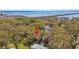 Aerial view of a single-Gathering home surrounded by mature trees with a view of the bay and bridge in the distance at 3010 County Road 31, Clearwater, FL 33759