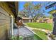 View of patio and spacious backyard with a lush lawn, a shed, and mature trees at 3010 County Road 31, Clearwater, FL 33759