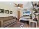 Cozy bedroom with wood-look flooring, a couch, a ceiling fan, and beach-themed decor at 3010 County Road 31, Clearwater, FL 33759