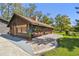 Exterior view featuring brick-paved porch, charming architecture, flower boxes, and lush lawn at 3010 County Road 31, Clearwater, FL 33759