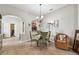 Dining area featuring a glass table, chandelier, and wicker armchair at 31820 Blythewood Way, Wesley Chapel, FL 33543