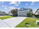 Charming home with well-maintained landscaping, lush green lawn, and a gray two-car garage in a residential neighborhood at 31820 Blythewood Way, Wesley Chapel, FL 33543